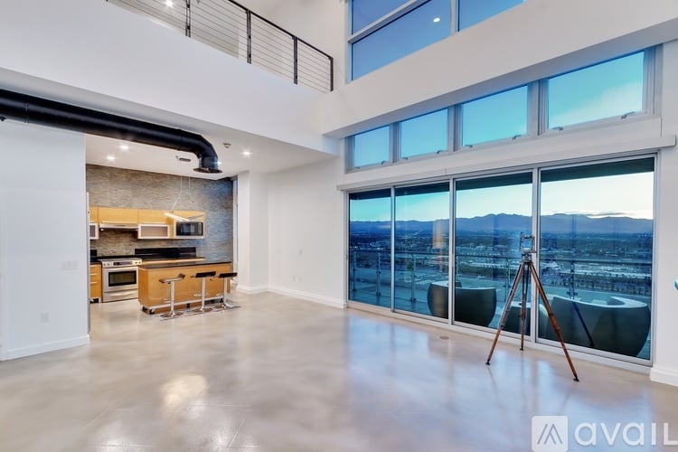A spacious, empty room with a large window overlooking a cityscape.