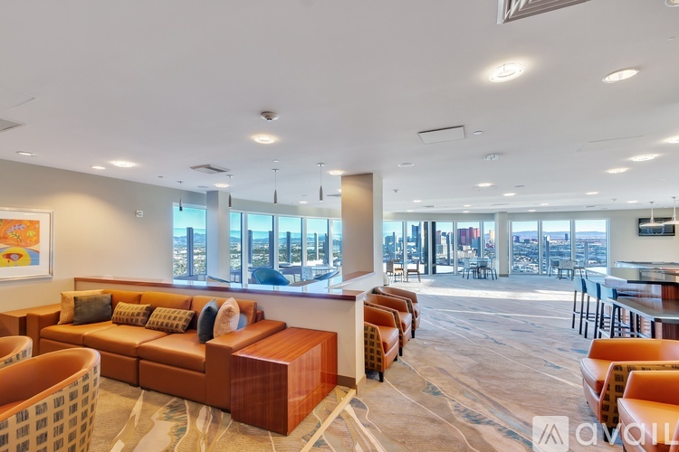 A spacious living room with a large window overlooking the city.