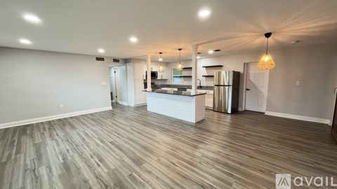 A spacious kitchen with a refrigerator, microwave, and oven.