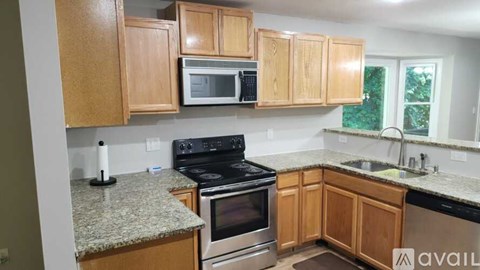 A kitchen with wooden cabinets and granite countertops.