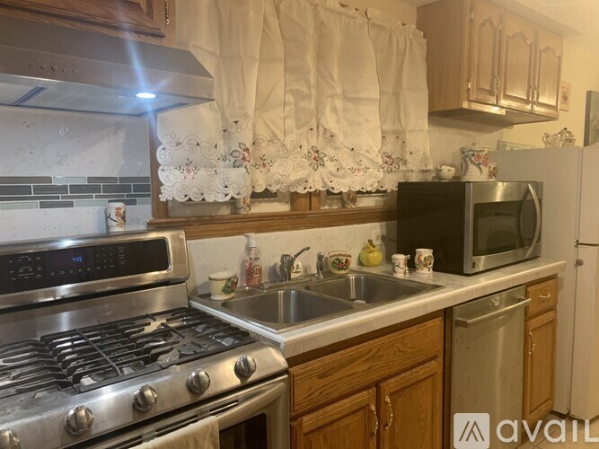 A kitchen with a stove, sink, and microwave.