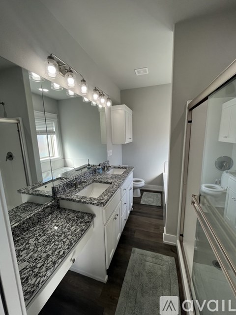 A bathroom with granite countertops and a walk-in shower.