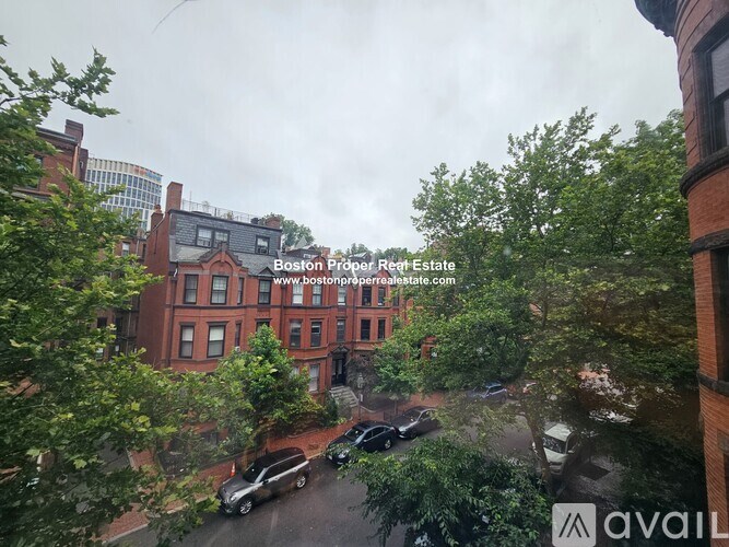 A view of a street from a window with a sign that reads "Boston Property Real Estate".