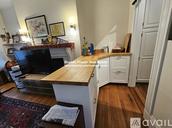 A living room with a couch, a fireplace, and a rug.