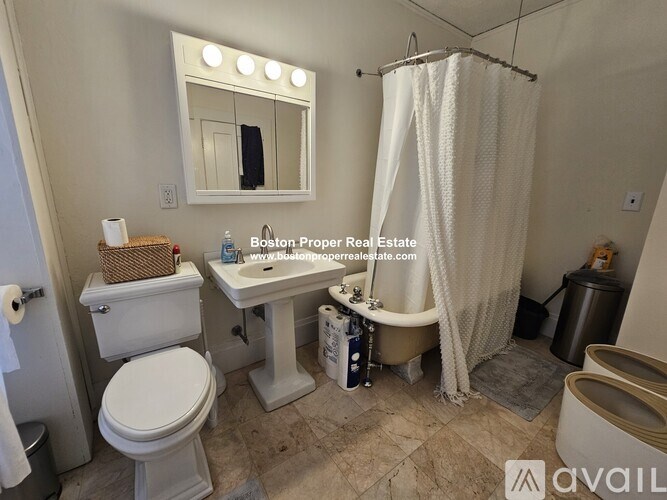 A bathroom with a toilet, sink, and shower.