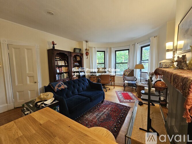 A living room with a blue couch and a wooden table.