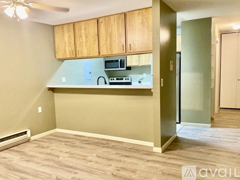 A kitchen area with wooden cabinets and a countertop.