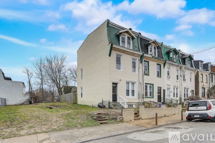 A row of houses with a car parked in front of the first one.