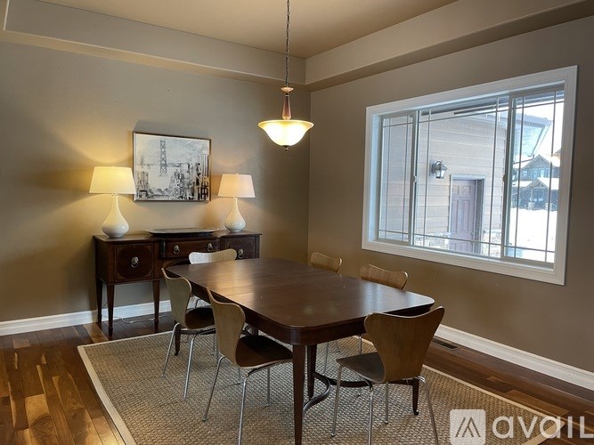 A dining room with a wooden table and chairs.