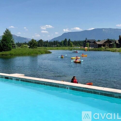 A group of people kayaking in a lake with a mountain in the background.