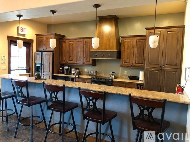 A kitchen with wooden cabinets and bar stools.