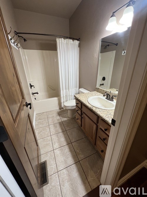 A bathroom with a sink, mirror, and shower.