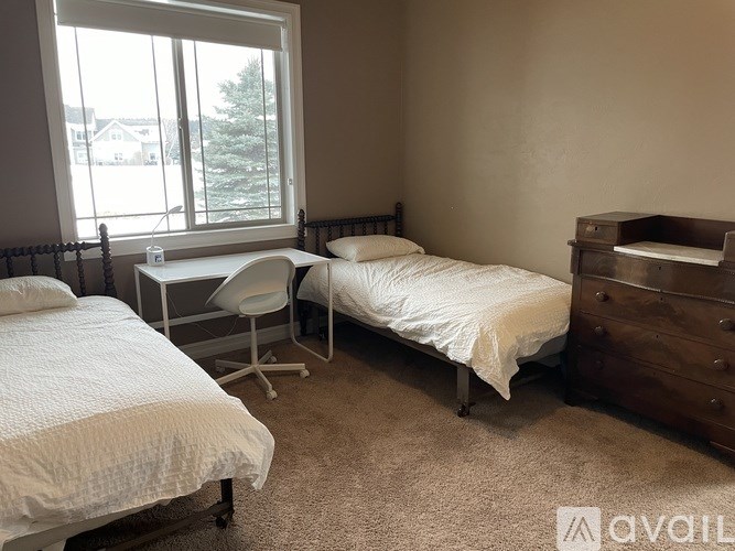 A bedroom with a bed, chair, and dresser.