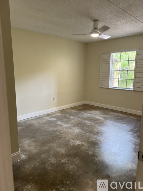 A room with a window and a fan on the ceiling.