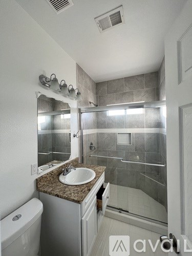 A bathroom with a sink, mirror, and toilet.