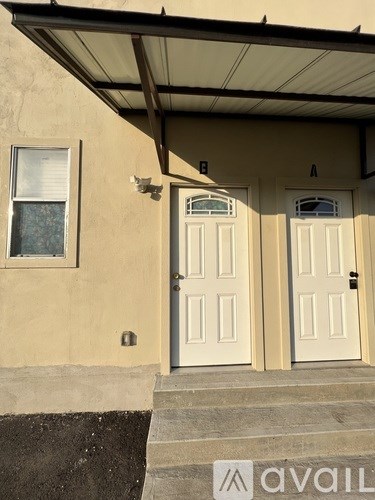 A house with a white door and a window is available for rent.