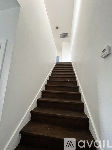 A staircase with brown steps leading to a door at the end.