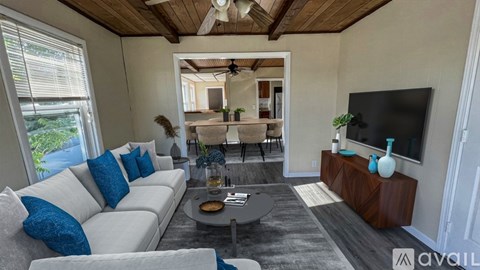 A modern living room with a white sofa and a wooden ceiling.