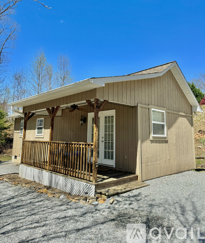 A small wooden house with a porch and a covered entrance.