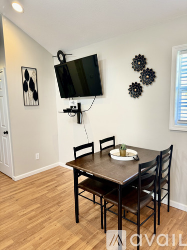 A dining room with a wooden table and chairs.