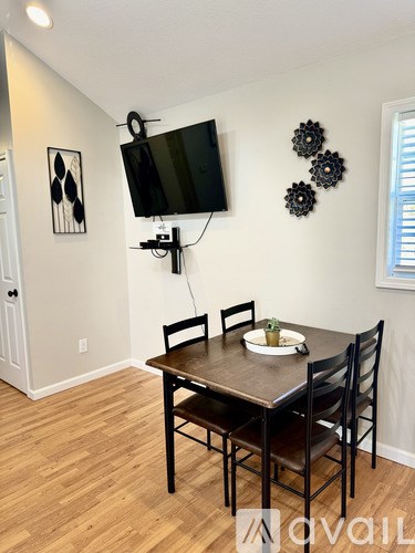 A dining room with a wooden table and chairs.