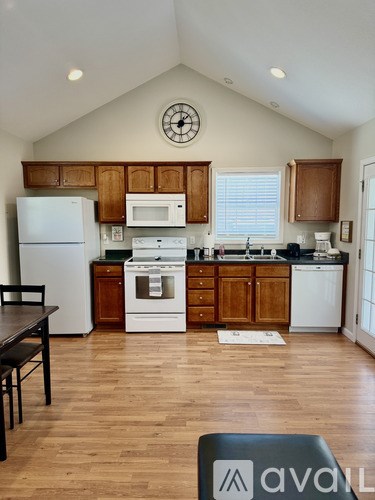 A kitchen with wooden cabinets and a white fridge.