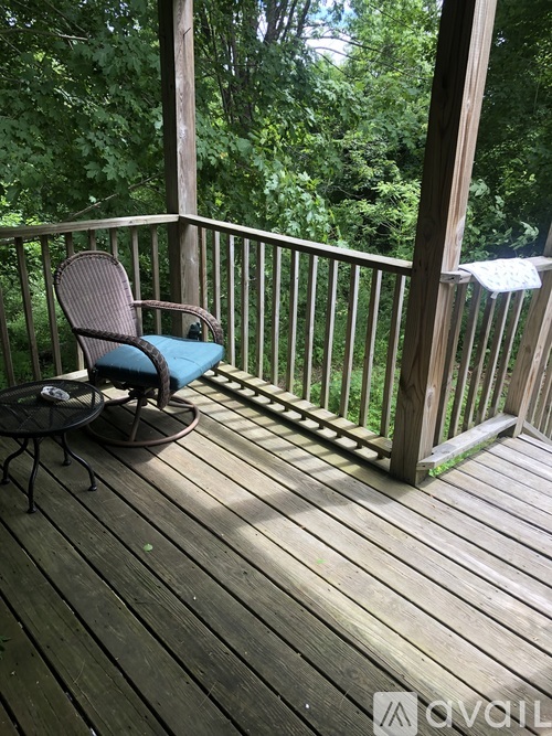 A chair and table are on a wooden deck.
