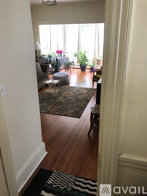 A living room with a rug on the floor and a couch.