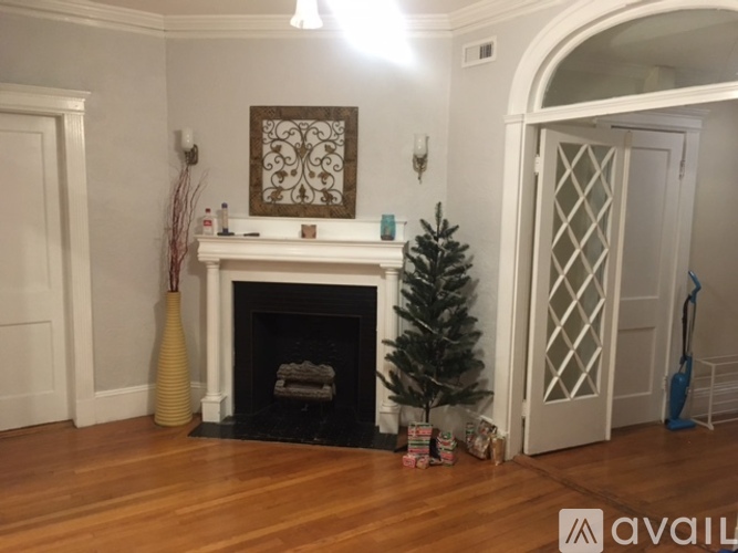 A living room with a fireplace and a Christmas tree.