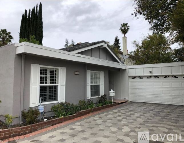 A house with a grey exterior and a white garage door.