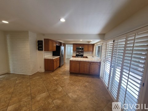 A kitchen with brown cabinets and a tiled floor.