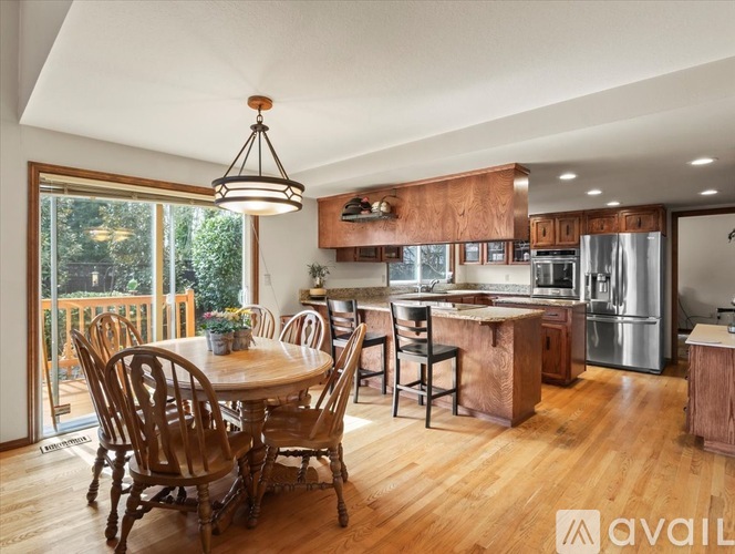 A kitchen with wooden chairs and a table is available for rent.