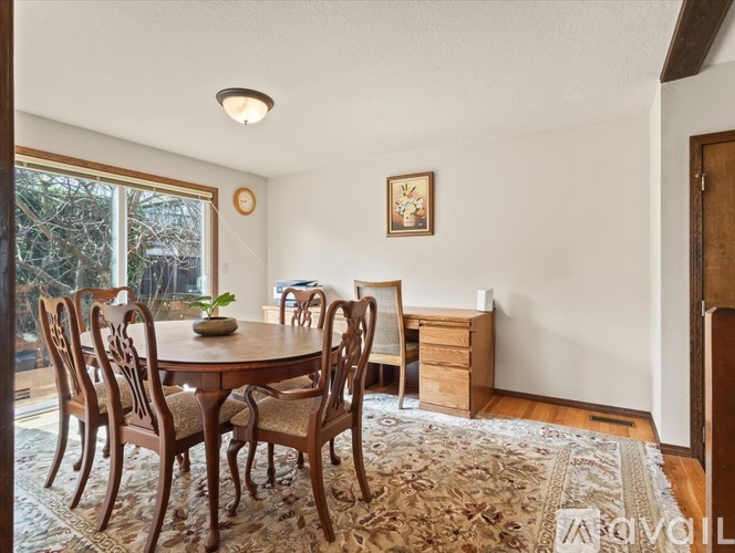 A dining room with a round table and chairs.