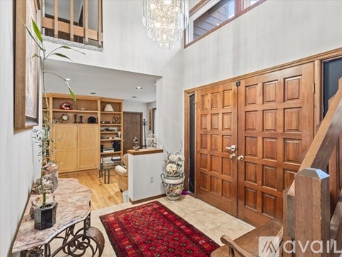 A living room with a red rug and a wooden door.