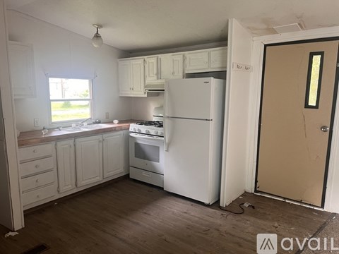 A kitchen with white appliances and cabinets is available for rent.