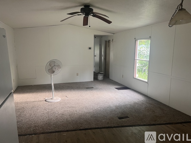 A room with a ceiling fan and a window.