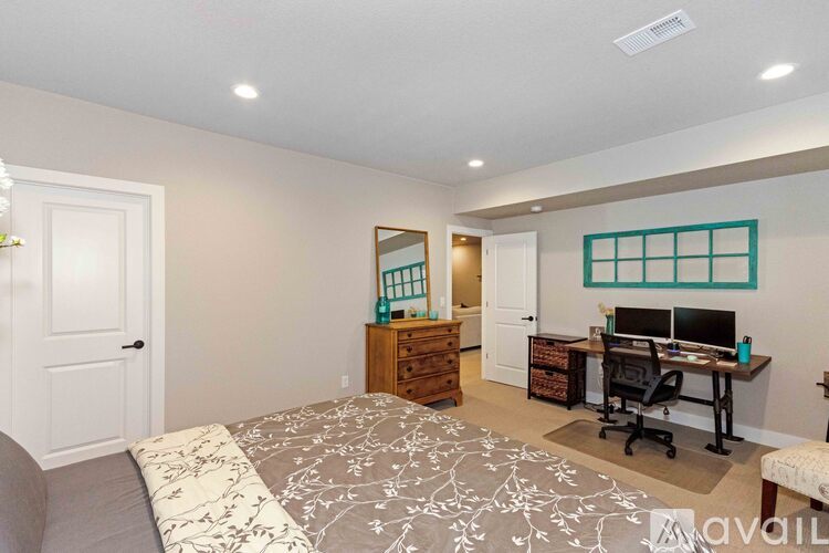 A bedroom with a bed, desk, and chair.