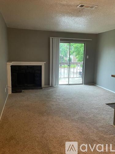 A living room with a fireplace and carpeted floor.