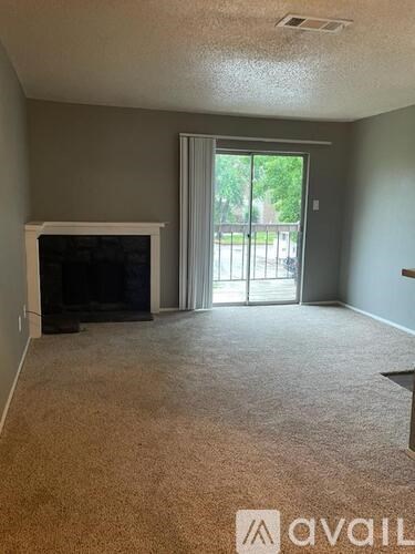 A living room with a fireplace and carpeted floor.