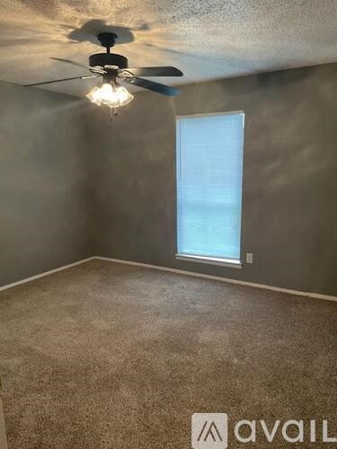 A room with a ceiling fan and a window.