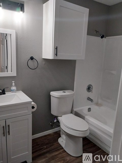 A white toilet sits next to a white sink in a small bathroom.