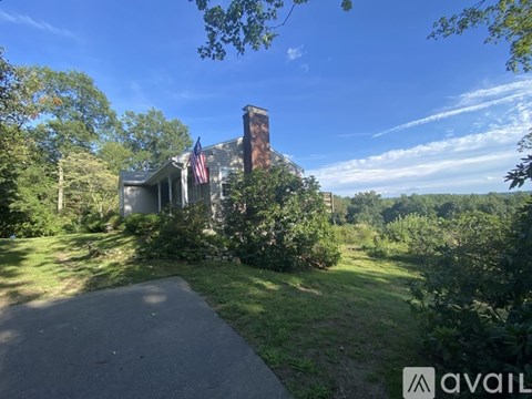 A house with a chimney and an American flag on the front porch.