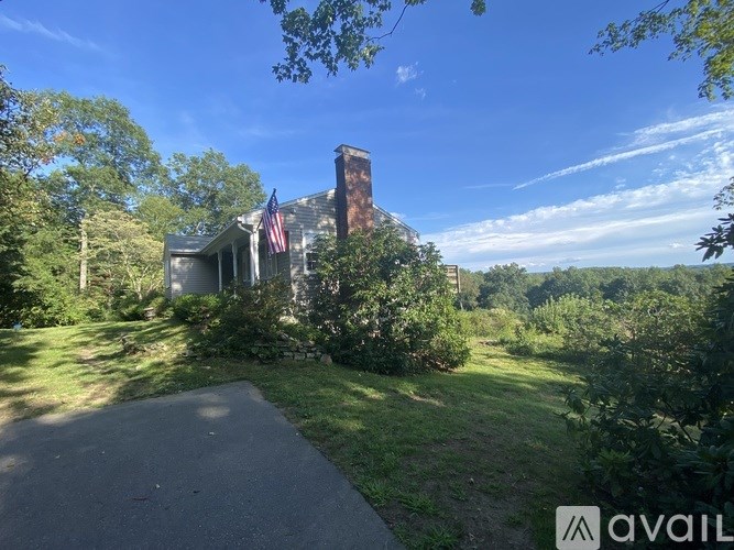 A house with a chimney and an American flag on the front porch.