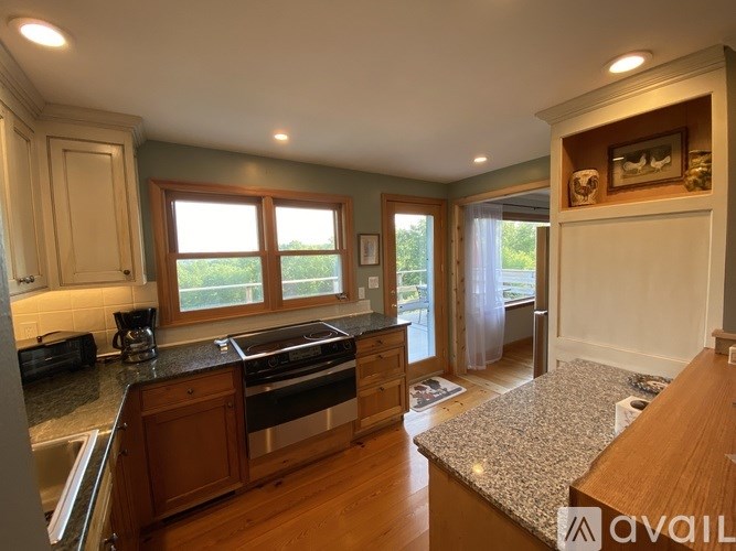 A kitchen with wooden cabinets and a granite countertop.