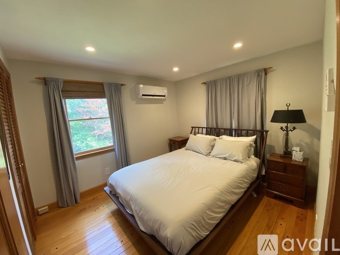 A bedroom with a large bed and wooden floors.