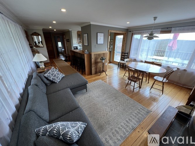 A living room with a grey couch and a wooden floor.