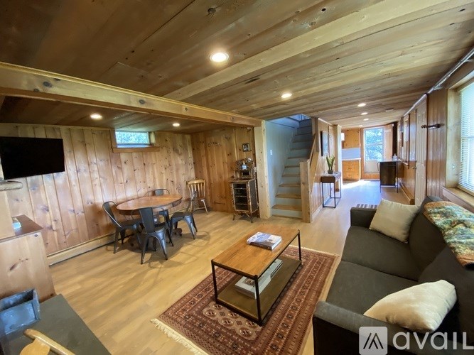 A living room with wooden walls and a television.