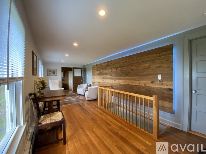 A living room with a wooden floor and a wooden wall.