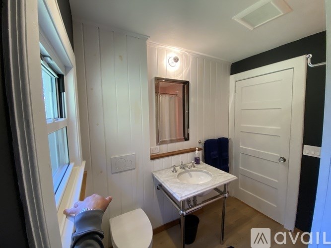 A bathroom with a sink, toilet, and mirror.