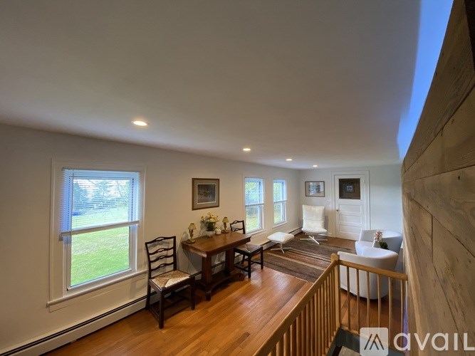 A living room with a wooden floor and a large window.